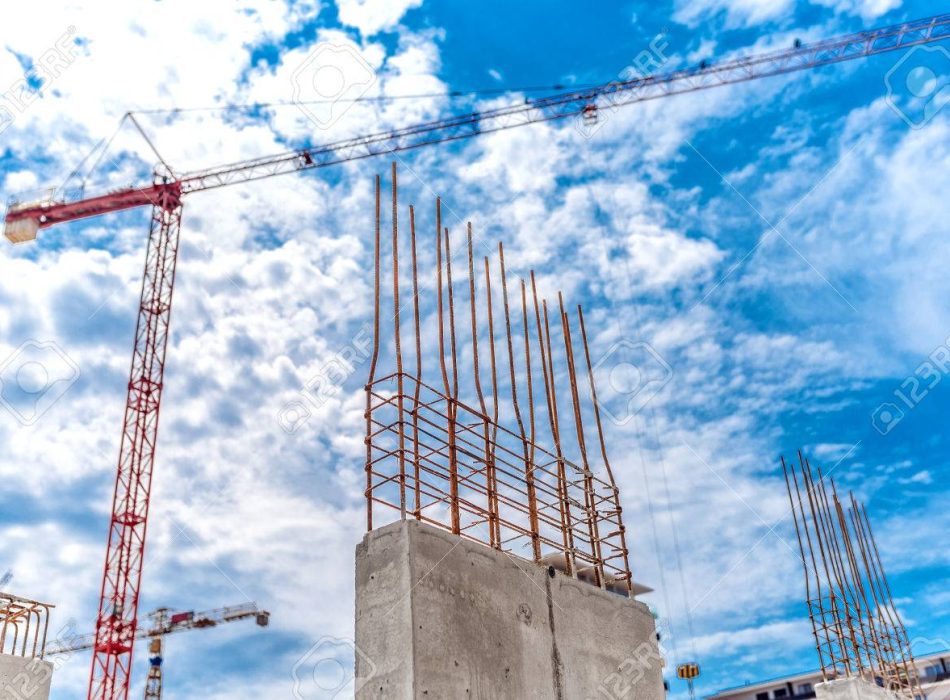 Construction site with industrial crane and close up of reinforced concrete walls, building of skyscraper office building
